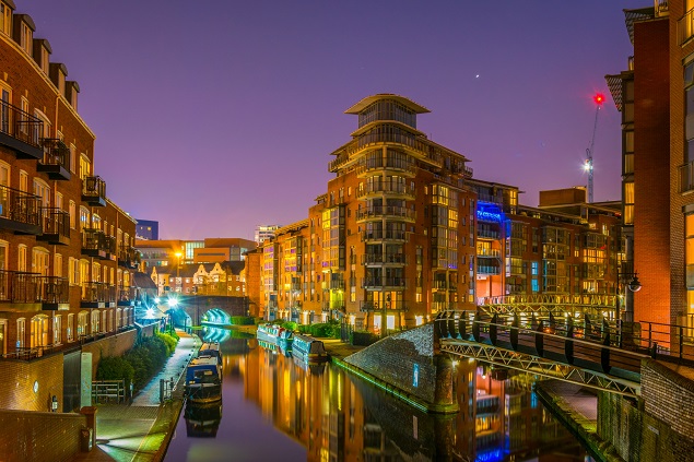 Photo of Birmingham at night, the river in the foreground and buildings in the background