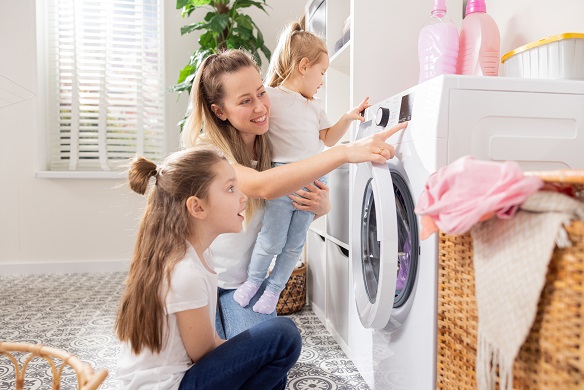 Mother and two children doing the laundry