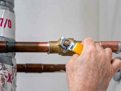 Man turning off the stopcock in his home